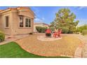 Cozy backyard featuring a fire pit, red chairs, and low-maintenance landscaping at 10801 Clarion Ln, Las Vegas, NV 89134