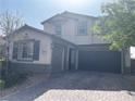 Two-story home with a three-car garage, neutral stucco, and a brick paved driveway at 12243 Pacific Cruise Ave, Las Vegas, NV 89138