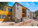 Apartment complex with balconies, desert landscaping and yellow exterior accents on a sunny day at 2700 N Rainbow Blvd # 1080, Las Vegas, NV 89108