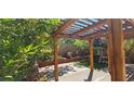 Pergola covered patio with swing, potted plants and brick planters at 3131 Binaggio Ct, Las Vegas, NV 89141