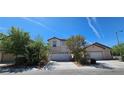 Inviting two-story home with a two-car garage, desert landscaping, and a bright blue sky at 3131 Binaggio Ct, Las Vegas, NV 89141