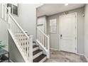 Bright entryway with a staircase featuring white railings, dark wood steps, and stylish tile flooring at 334 E Neal Ave, Las Vegas, NV 89183