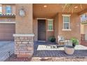 Welcoming front porch featuring stone pillars, a cozy seating area, and a stylish front door at 334 E Neal Ave, Las Vegas, NV 89183