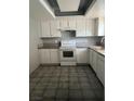A kitchen featuring white cabinets, gray countertops, and tile flooring at 3692 Garden South Dr # 0, Las Vegas, NV 89121