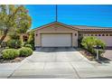 Attractive home boasts a wide driveway, a two-car garage and manicured landscaping at 4802 Regalo Bello St, Las Vegas, NV 89135