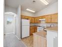 Bright kitchen featuring wood cabinets, a white refrigerator, and tile flooring at 4830 Double Down Dr # 102, Las Vegas, NV 89122