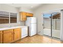 Bright kitchen featuring tile flooring, wooden cabinets, and access to the backyard at 5373 Blue Oat Ave, Las Vegas, NV 89141
