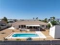 Backyard showcases a pool, hot tub, covered patio, and desert-friendly landscaping, creating a serene outdoor retreat at 5450 Grain Mill Rd, Pahrump, NV 89061