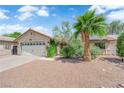 Charming single-story home featuring a well-maintained front yard with a palm tree and a two-car garage at 5884 Deer Valley Dr, Las Vegas, NV 89156