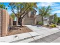 Attractive home with a two-car garage, complemented by low-maintenance landscaping and mature shade trees at 6282 Dollar Bill Ct, Las Vegas, NV 89141