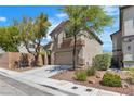 Inviting two-story home with a neutral exterior, mature trees, and a spacious driveway leading to a two-car garage at 6282 Dollar Bill Ct, Las Vegas, NV 89141