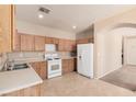 Well-lit kitchen featuring wooden cabinets and standard appliances at 6620 Tulip Falls Dr, Henderson, NV 89011