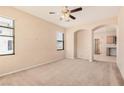Neutral living room with carpet, ceiling fan, and archway at 6620 Tulip Falls Dr, Henderson, NV 89011