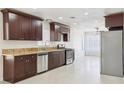 Updated kitchen with stainless appliances, dark wood cabinets, and granite countertops at 7139 Mountain Moss Dr, Las Vegas, NV 89147