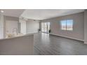 Sunlit living room boasts neutral walls, stylish tile floors, and glass doors to a private balcony with views at 8255 S Las Vegas Blvd # 2004, Las Vegas, NV 89123