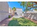 Fenced backyard featuring lush green grass and a concrete patio area perfect for entertaining at 9979 Keephills St, Las Vegas, NV 89183