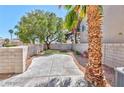 Private fenced backyard featuring a concrete patio area, low maintenance gravel bed, and mature trees at 9979 Keephills St, Las Vegas, NV 89183