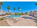 Relaxing community pool with lounge chairs surrounded by palm trees and nearby restrooms at 9979 Keephills St, Las Vegas, NV 89183