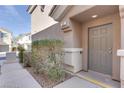 Townhome front entrance with neutral desert colors and minimal landscaping at 9994 Government Point Way # 101, Las Vegas, NV 89183