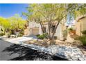 Lovely home showcasing a neatly maintained front yard with mature shade trees and an attached garage at , Las Vegas, NV 89178
