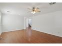 Bright living room with hardwood floors, ceiling fan, and access to staircase at 1043 Monte De Oro Ave, Las Vegas, NV 89183