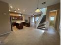 Open kitchen with granite countertops, stainless steel appliances, a center island, and staircase access at 11237 Newbury Hills Ave, Las Vegas, NV 89138