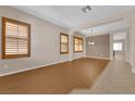 Spacious living room featuring beautiful wood floors, shuttered windows, and neutral paint tones at 11237 Newbury Hills Ave, Las Vegas, NV 89138