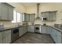 A modern kitchen features gray cabinetry, stainless appliances, and a large window at 1409 Denver St, Boulder City, NV 89005
