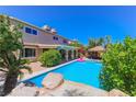 Backyard oasis featuring a sparkling pool, lush greenery, and a charming poolside tiki hut for ultimate relaxation at 1440 Rawhide Rd, Boulder City, NV 89005