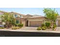 Inviting home featuring a well-kept lawn, desert landscaping, and a two-car garage at 2434 Quiet Ode St, Henderson, NV 89044