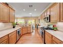 Well-lit kitchen featuring stainless steel appliances, wood cabinetry, and a view of the patio at 2545 Nashira St, Henderson, NV 89044