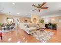 Open-concept living area featuring hardwood floors, ceiling fan, comfortable furniture and adjacent dining area at 2545 Nashira St, Henderson, NV 89044