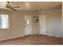 Living room with hardwood floors, two doors, and a large window for natural light at 2700 W Prospector Ln, Pahrump, NV 89048