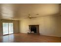 Living room with hardwood floors, brick fireplace, and large glass sliding doors for natural light at 2700 W Prospector Ln, Pahrump, NV 89048