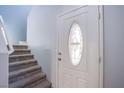 Inviting entryway featuring a carpeted staircase and front door with decorative glass panel at 433 Royal Bridge Dr, Las Vegas, NV 89178