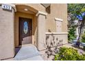 Close-up of front door with decorative glass detail and address number, enhanced by manicured landscaping at 433 Royal Bridge Dr, Las Vegas, NV 89178