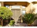 Inviting home entrance with ornate double doors, lush landscaping, and warm, welcoming ambiance at 4554 Blue Mesa Way, Las Vegas, NV 89129