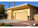 Spacious three-car garage featuring an arched entrance and well-maintained landscaping at 4554 Blue Mesa Way, Las Vegas, NV 89129
