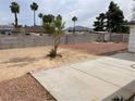 Wide backyard featuring desert landscaping, concrete patio, and a sturdy block wall for privacy at 4564 Dennis Way, Las Vegas, NV 89121