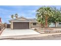 Charming single-story home featuring a well-manicured lawn, mature palm trees, and a two-car garage at 516 Donner St, Las Vegas, NV 89107
