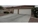 Home exterior featuring a two-car garage and low-maintenance landscaping at 5318 Rio Eldorado Ct, North Las Vegas, NV 89031
