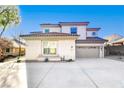 Two-story house with a beige stucco exterior, tile roof, and a three-car garage at 5737 Heather Breeze Ct, Las Vegas, NV 89141