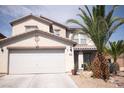 Home exterior featuring a two-car garage and well-kept xeriscaped front yard with palm trees at 6141 Annville Ct, North Las Vegas, NV 89081
