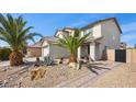 Inviting two-story home featuring desert landscaping, palm trees and a two-car garage at 6141 Annville Ct, North Las Vegas, NV 89081