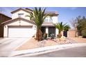 Two-story home with a two car garage, palm trees, and rock landscaping at 6141 Annville Ct, North Las Vegas, NV 89081