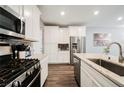 Bright kitchen showcasing stainless steel appliances, an island with a sink, and a brick-style backsplash at 6228 Haiku Stairs St, Las Vegas, NV 89148