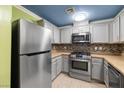 Modern kitchen with stainless steel appliances, granite countertops, tile backsplash, and ample cabinet space at 6655 Flaminian Ln # 104, North Las Vegas, NV 89084