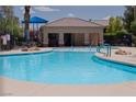 Community pool featuring a splash pad, lounge seating, shade structures, and lush landscaping at 6655 Flaminian Ln # 104, North Las Vegas, NV 89084