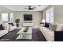Staged living room with plush seating, a modern coffee table, and large windows at 7624 Mallard Bay Ave, Las Vegas, NV 89179