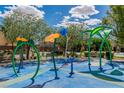 Community water play area with colorful sprayers and benches for relaxing on a sunny day at 7624 Mallard Bay Ave, Las Vegas, NV 89179